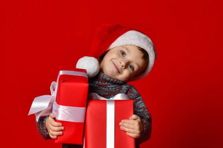 手拿圣诞礼物的圣诞老人的红色帽子有趣微笑儿童
