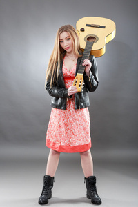 美丽的年轻金发女郎，有着古典吉他