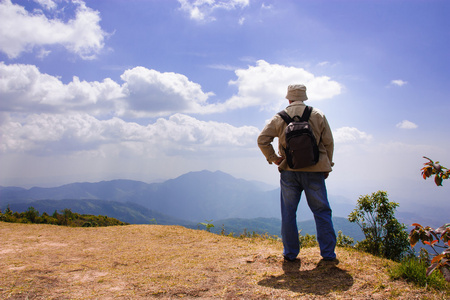 人站在山顶，背包里的旅行者