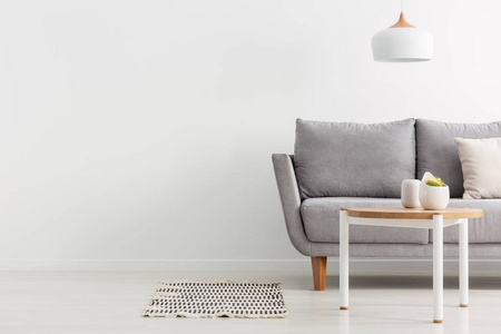 在明亮时尚的客厅的照片复制空间与灰色舒适的沙发和简单的木茶几, 真实的照片