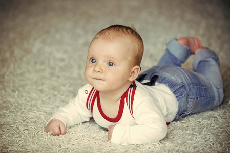 童年, 婴儿, 新生儿。婴儿在地板地毯上爬行。儿童发展概念。可爱的脸上蓝眼睛的婴儿。纯真, 美丽, 纯洁