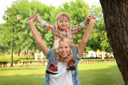 快乐的母亲与儿子在绿色公园