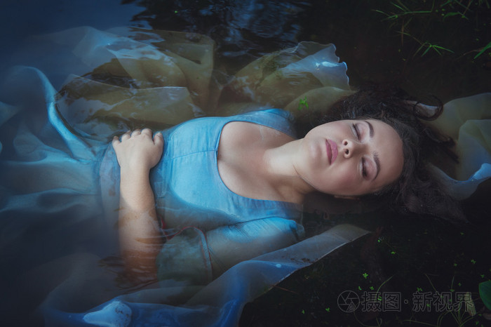 年轻美女穿着蓝色的衣服躺在河里淹死