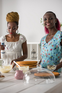 非洲妇女烹饪与草莓蛋糕
