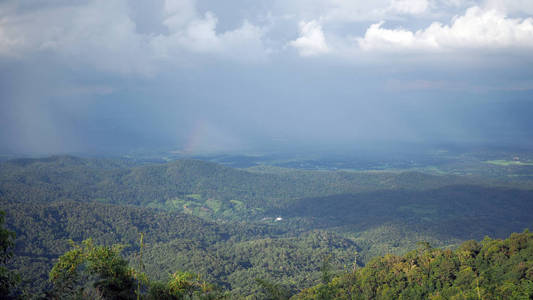 风景山山谷。背景蓝色天空与白色充满雨云