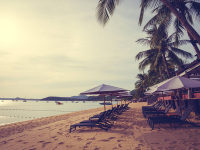 在日出时的热带海滩海洋和海洋的雨伞和椅子旅行和度假