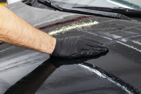 一个男子清洁汽车与超细纤维布, 汽车详细 或 valeting 概念。选择性对焦。汽车详细说明。用海绵清洗。工人清洗。超细纤