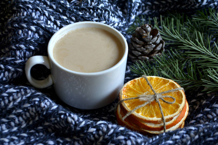 一杯咖啡用牛奶松枝在针织毛毯上干橘子