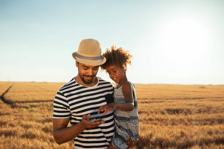 一个非洲裔美国人的父亲的肖像显示小麦给他的女儿在田间