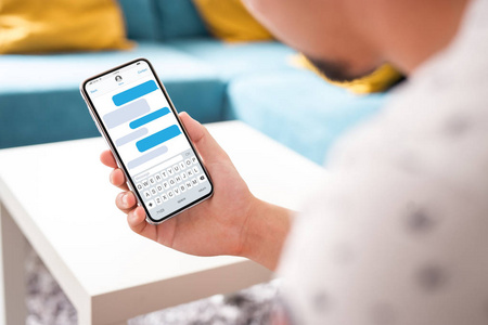 手持黑色智能手机与 sms 应用程序显示在屏幕上现代框架较少设计家居内饰, 起居室隔离在白色背景角度的位置