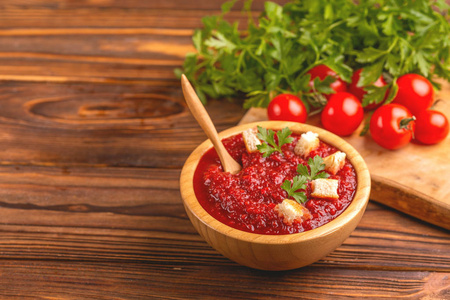 鲜可口的泥番茄汤, 木碗配配料。健康食品概念。质朴的木制背景。复制空间