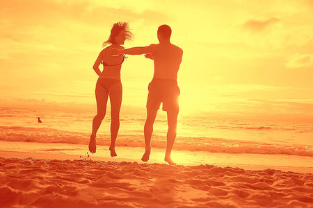 日落美景, 沙滩上的年轻快乐恋人剪影。新婚夫妇蜜月度假酒店