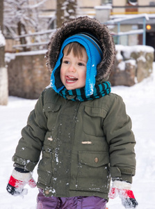 小男孩在夹克和针织帽子捕捉雪花在冬季公园圣诞节。孩子们在雪地里玩耍。冬天玩雪的孩子