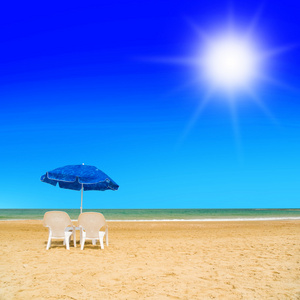 对日光躺椅和海滩伞在荒凉的海滩上