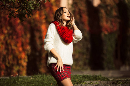 美丽的女人穿着时尚衣服在秋季公园