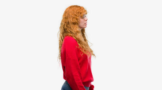 身穿红色毛衣的年轻红衫女郎看着身边, 放松姿态带着自信微笑的自然面孔