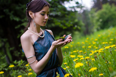 在抱着一只蝴蝶蒲公英女孩