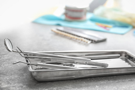 灰色桌上有牙医工具的托盘