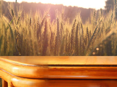 面前的麦田上夕阳光木板桌子。准备产品显示蒙太奇