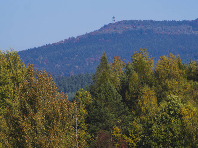 与秋天五颜六色的森林和树木和丘陵与 Hvozd 或霍赫瓦尔德瞭望塔和 luzicke 霍里山的蓝天景观草甸