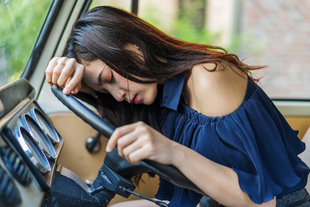 年轻女子睡在老式的汽车