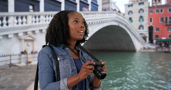 迷人的黑人妇女拍照照片在威尼斯风景秀丽的大运河与相机