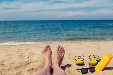 沙滩上的人在日光浴。脚和触发器的浅景深