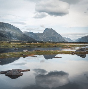 清澈的水中群山的神奇倒影。在挪威北部的夏季旅行。挪威