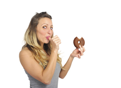 年轻的顽皮女人吃巧克力甜甜圈快乐有罪为不良的营养状况