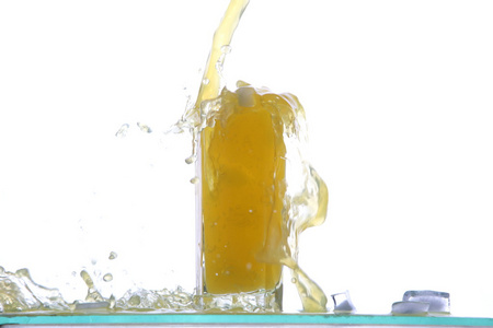 柠檬果汁玻璃用柠檬片，与汁飞溅，在白色背景上孤立