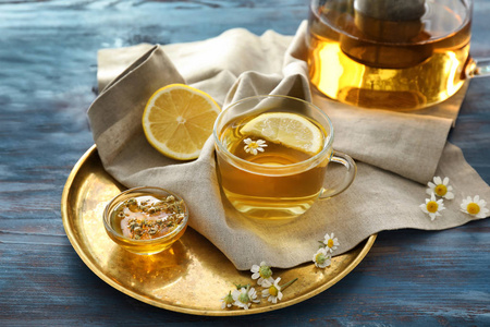 一杯美味的甘菊茶和蜂蜜在木桌上