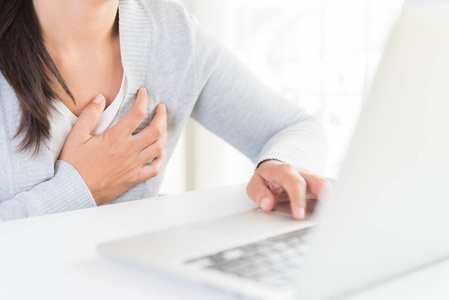 有心脏病发作的特写女郎。女人摸乳房, 长时间工作在电脑后胸部疼痛。办公室综合症医疗保健和医学概念