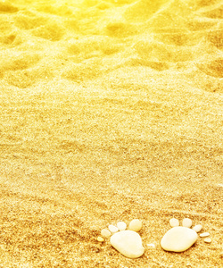 成人的人类脚印或脚踩灰色沙滩