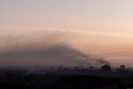 工厂的大型管道在日落时污染化学排放环境