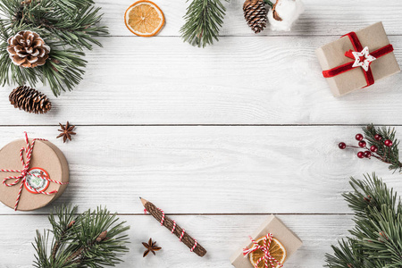 圣诞礼品盒在白色木背景与冷杉分枝, 松果。圣诞节和新年快乐主题。平面布局, 顶部视图, 文本空间