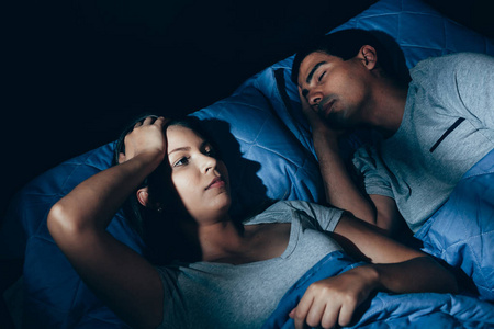 人，健康，睡眠障碍概念   对夫妇在家里的床上，打鼾的人饱受失眠之苦的年轻女人