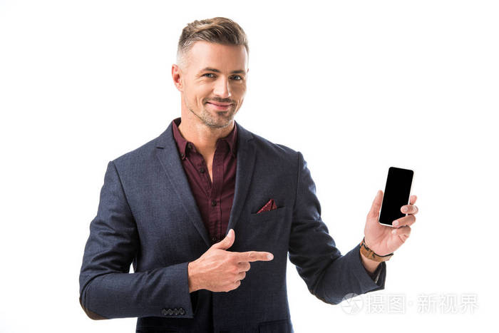 积极的成人时尚男子在夹克用手指指着智能手机与空白屏幕隔离在白色