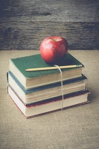 书籍和复古背景与 Instagram 样式过滤器上的苹果
