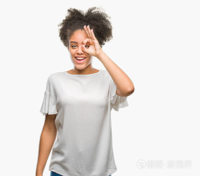独立背景的年轻美国黑人妇女做 ok 手势用手微笑, 眼睛看通过手指与