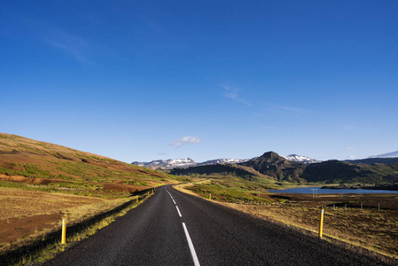 在冰岛的道路。享有山景的夏季景观。晴朗的蓝天, 阳光明媚的天气