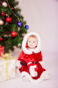 在圣诞老人服装在圣诞树上的宝贝