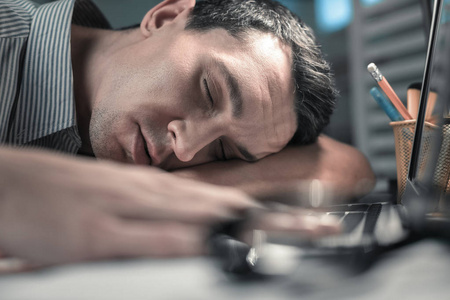 躺在桌子上的昏昏欲睡的工人肖像