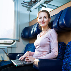 年轻女子使用她的便携式计算机上火车