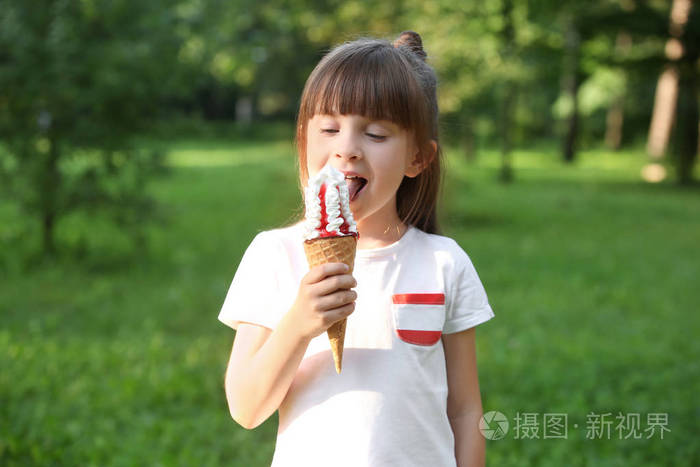 夏天的时候在公园里吃冰淇淋的可爱的小女孩