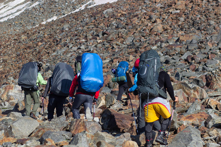 一群背着大背包旅游者在雷暴对山