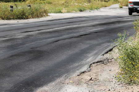 危险路面：老旧风化破碎脏污的黑色道路