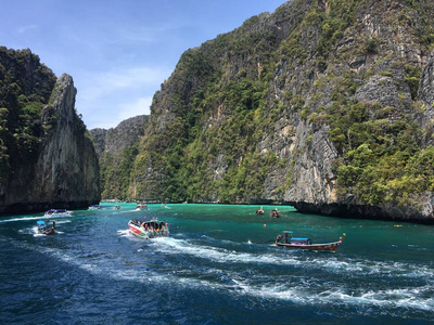 海湾与蓝色水在两个海岛之间在泰国漂浮小船