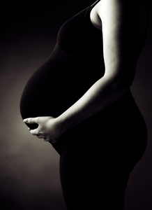 怀孕的女人支持她的肚子里图片