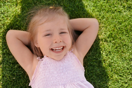 可爱的小女孩在公园的阳光明媚的一天放松