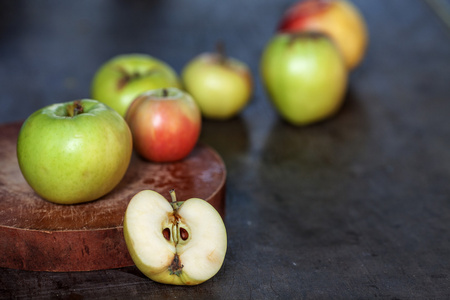 有几个苹果上雕刻板和一个半木制的桌子上的苹果